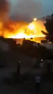 Fire rises from the police high school opposite the passport building in the Tagsat area in Gharyan, explosions of ammunition audible after LNA Air Force raid 